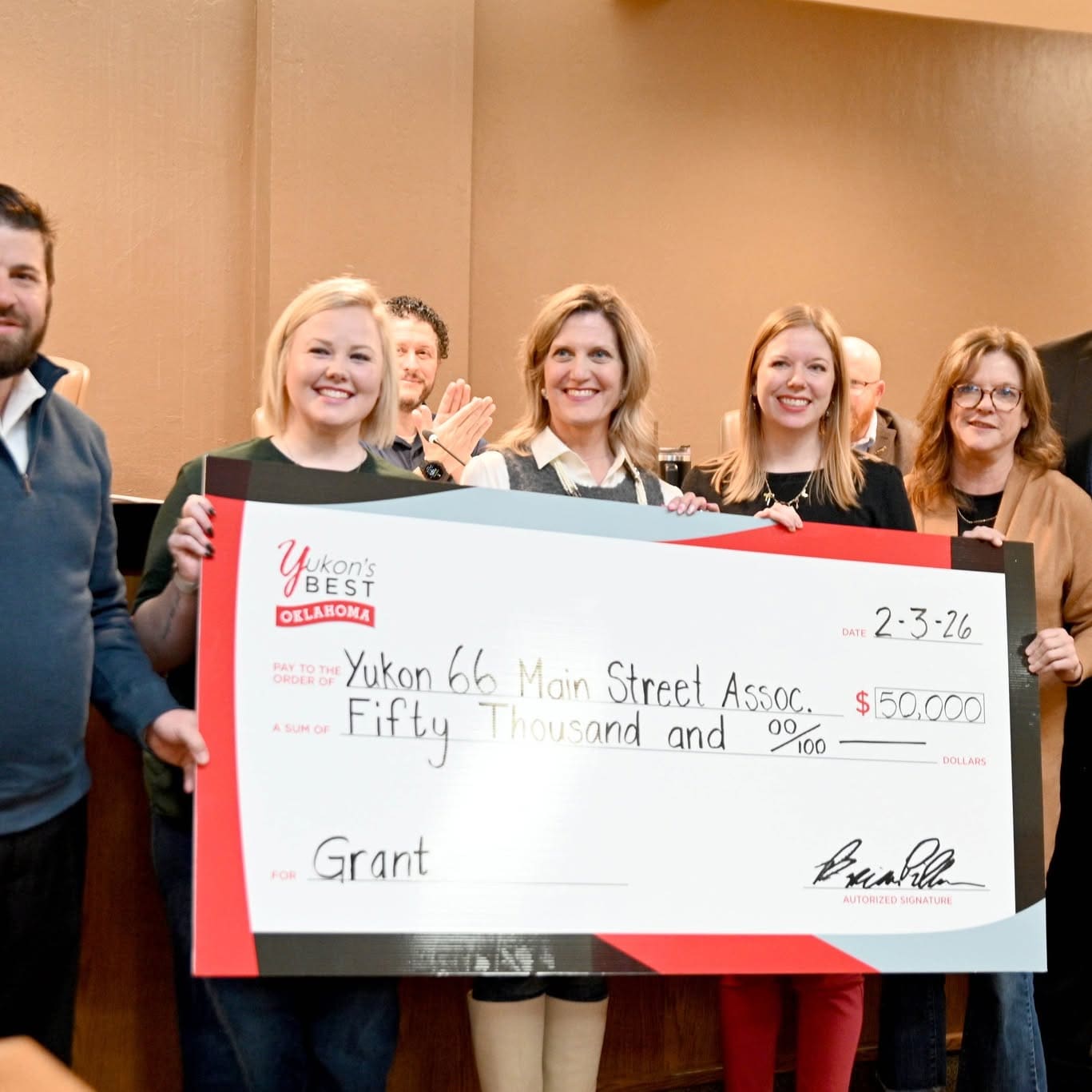 City officials and Main Street board members holding an oversized $50,000 grant cheque made out to the Yukon 66 Main Street Association